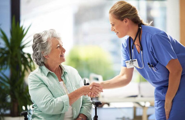 Older adults participate in gentle seated exercise together in a bright assisted living activity room.